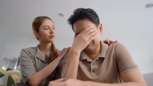 Woman Comforts a Crying Man in an Interior