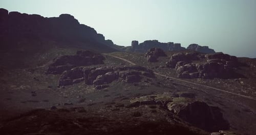 Exploring Rugged Mountain Terrain at Dusk with Rocky Formations in View