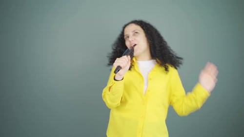 The young woman is singing.