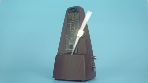 Traditional Pendulum Metronome On A Light Blue Background.