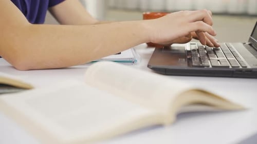 Close Up Of Person Studying At Desk