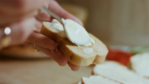 Mayonnaise is Spread on a Toasted and Seasoned Slice of White Bread Close Up