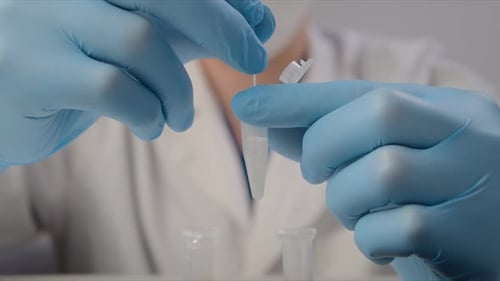 Une infirmière portant des gants en latex mélange des matériaux pour un test de
