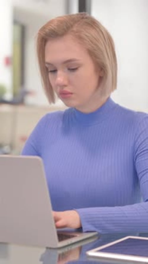 Young Woman Working on Laptop in Office, vertical video