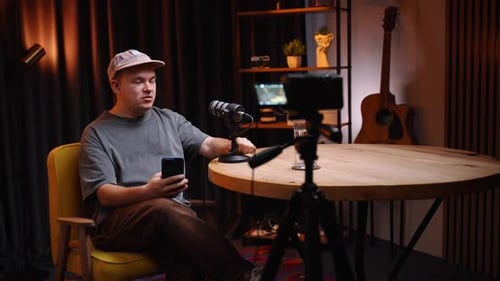Young Man Recording Podcast Interview Holding Smart Phone