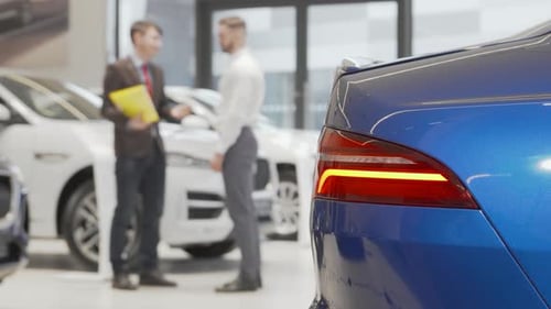 Car Dealer Shaking Hands with Male Client at Automobile Dealership