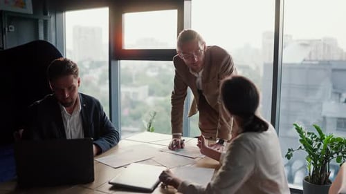 Young Boss in a Modern Office a Blond Man in Glasses with a Light Brown Beard Tells His Colleagues