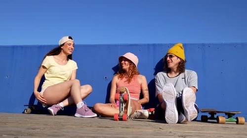 Friends Sit and Converse on Skateboards