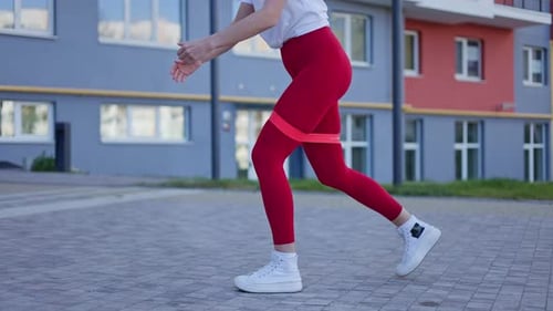 Woman Exercising with Resistance Band in Urban Setting