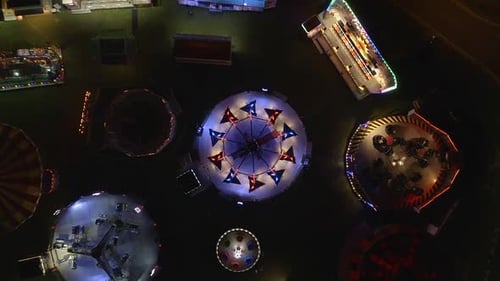 Experience the vibrant energy of an amusement park at night with this breathtaking aerial view of fl
