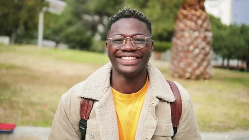 Close Up Portrait of African American Teenage Boy Looking at Camera Smiling and Laughing at
