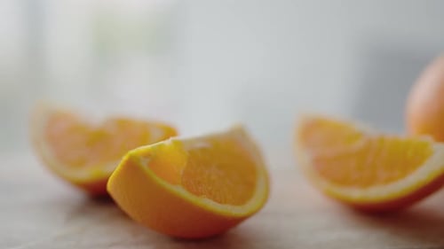 Nahaufnahme von frisch geschnittenen Orangen auf Holzoberfläche mit verschwommenem Hintergrund