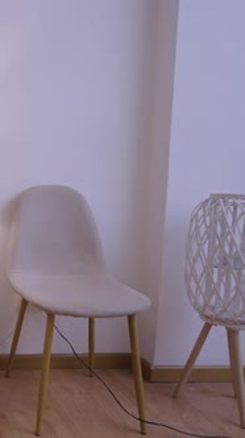 Camera Shows Chairs and a Small Table with a Lamp