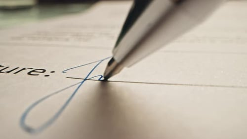 Close up shot of signature being signed on contract
