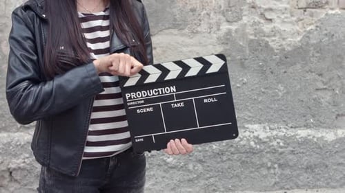 Young Brunette Woman with Cinema Clapper Board