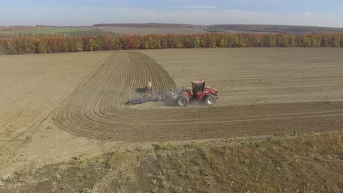 Big red tractor working on the field cultivating and applying nitrogen ASP