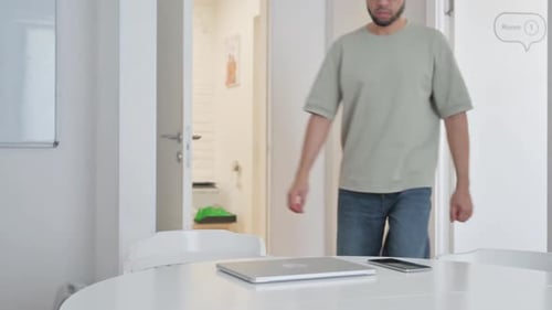 Man Opens Laptop at Minimalist Office Table