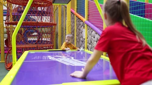 Happy Smiling Little Boy and Girl Play Air Hockey Funny Children Having Fun in Entertainment Center