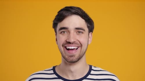 Happy Young Man Smiling in Front of Yellow Background