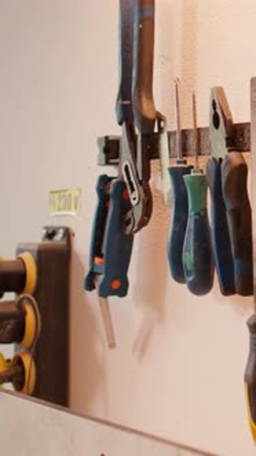 Vertical Video Chisels Screwdrivers Wrench and Pliers on Wall in Furniture Assembly Shop
