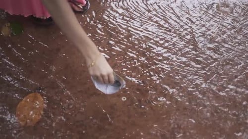 Paper Boat Floating on Rainy Puddle Surface