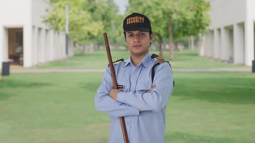 Security Guard Stands With Arms Crossed On Lawn