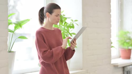 Woman Using Tablet Device Indoors
