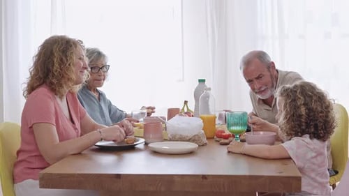 Four Family Members Eating Breakfast Indoors
