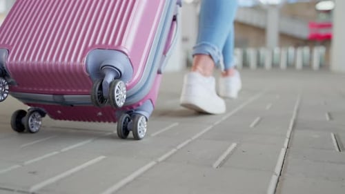 Woman with Wheeled Travel Suitcase Walking to the Station