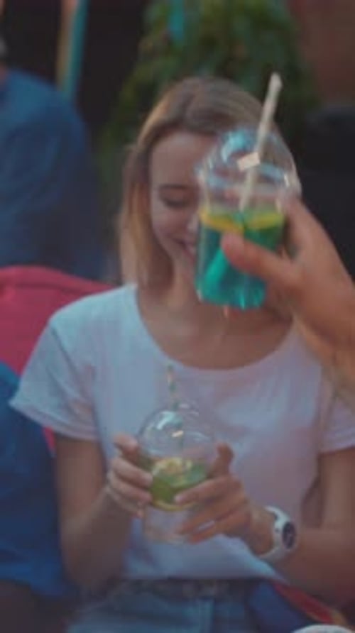 Young Woman Enjoys Beverage with Friends