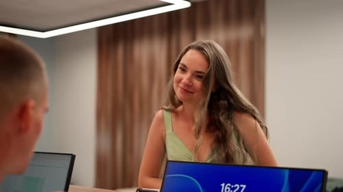 in a Modern Clinic at the Reception Desk a Young Girl in Green Summer Clothes Fills Out a Form with