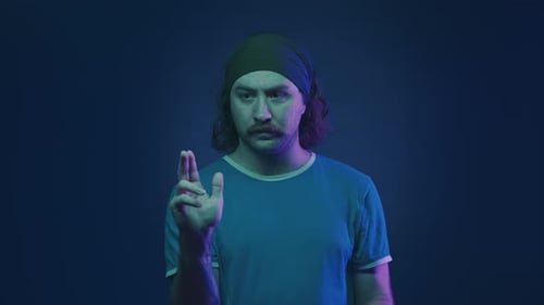 Focused Man Working on an Invisible Screen Portrait of a Mustachioed Man in a Headband in a Studio