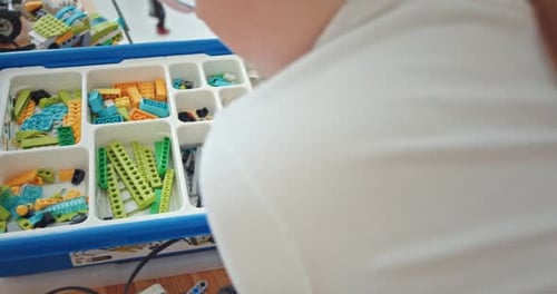 Nahaufnahme von Jungenhänden, die Roboter bauen und programmieren, im Robotikunterricht in der Schule