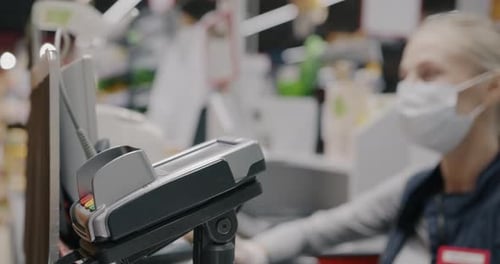 Nahaufnahme einer weiblichen Hand, die im Supermarkt drahtlos Online-Zahlungen mit Kreditkarte durchführt