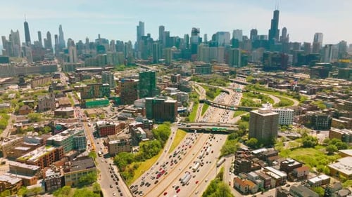 Lively picturesque picture of the city at sunny daytime. Crazy traffic along the multi-lane roads.