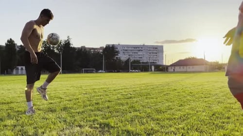 Two Sportsmen Showing Tricks with Ball While Passing It to Each Other at Field Young Men Kicking