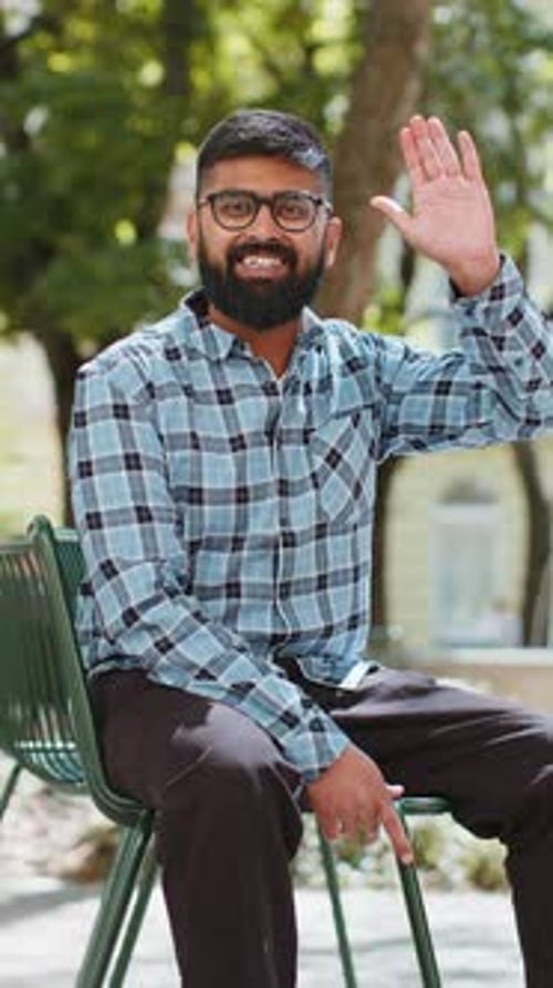 Indian Man Smiling Friendly at Camera Waving Hands Hello Hi Greeting or Goodbye in City Street