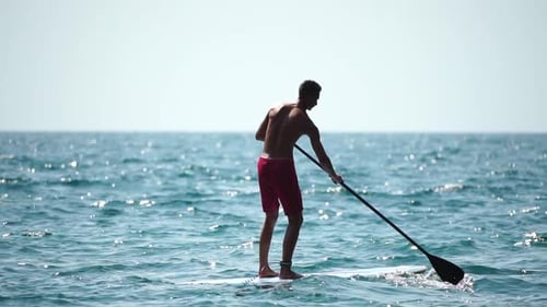 Man Sup Sea Strong Athletic Man Learns to Paddle Sup Standing on Board in Open Sea Ocean on Sunny