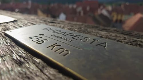 Close-up of a brass plate indicating the distance to Budapest from the Clock Tower in Sighișoara.