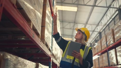 Woman worker checks products stock inventory with digital tablet in the retail warehouse