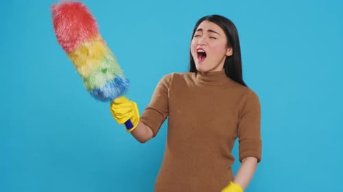 Tired Woman Yawns Holding Feather Duster