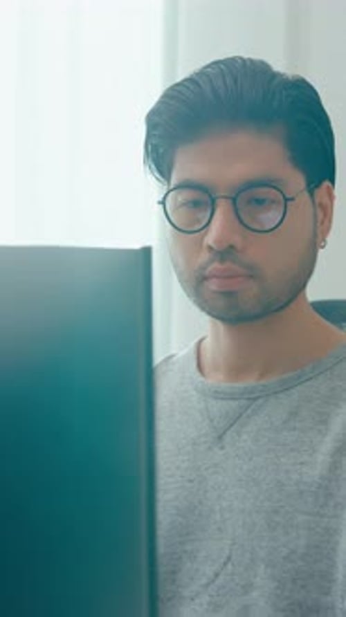 Lunettes de vue indépendantes pour hommes asiatiques pour jeunes adultes dactylographiant un codage AI rapide sur un ordinateur de bureau.