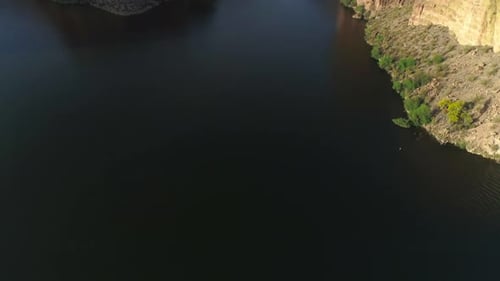 AERIAL - Drone Tilt Up to Reveal Waterway Between Mountains (Canyon Lake)