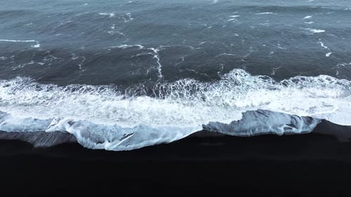 Aerial View of Black Sand Volcanic Beach with Crashing Waves Serene and Tranquil Landscape Famous