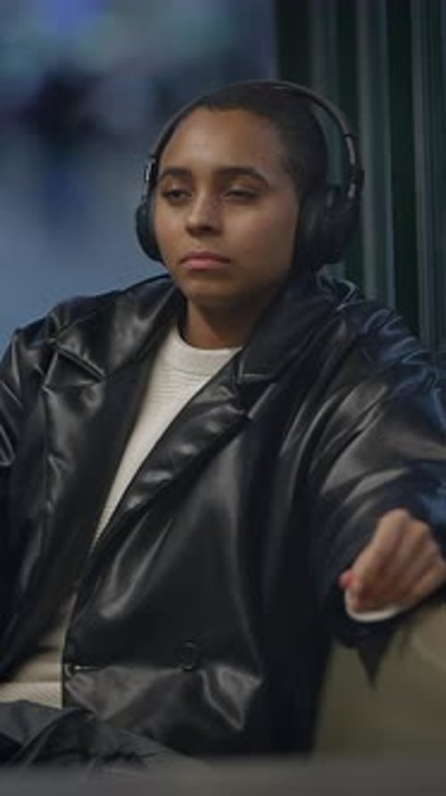 A Young Urban Commuter Enjoys Music in a Modern Setting Creating a Relaxed Vibe During Travel
