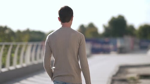 A Man Walking Away in the Bright Sunlight Embracing Adventure and Freedom As He Moves