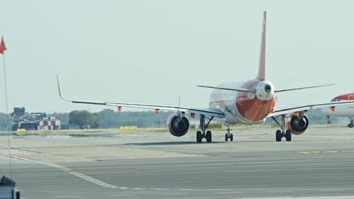 A commercial airplane taxis on the runway, preparing for takeoff during a bright day