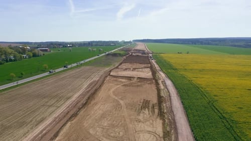Aerial view of building new road. Flight above construction site, new highway.