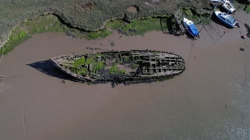 Shipwreck Covered With Moss Near Salt Marshes In Tollesbury Marina, Essex, United Kingdom. Aerial Ti