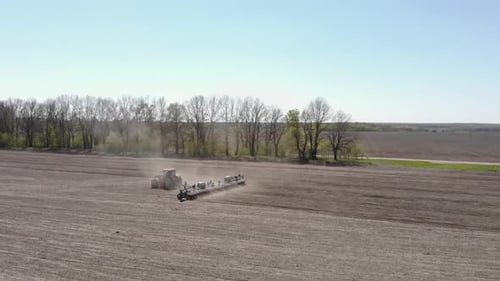 Big yellow tractor planting corn in Ukraine. Tractor working on the field